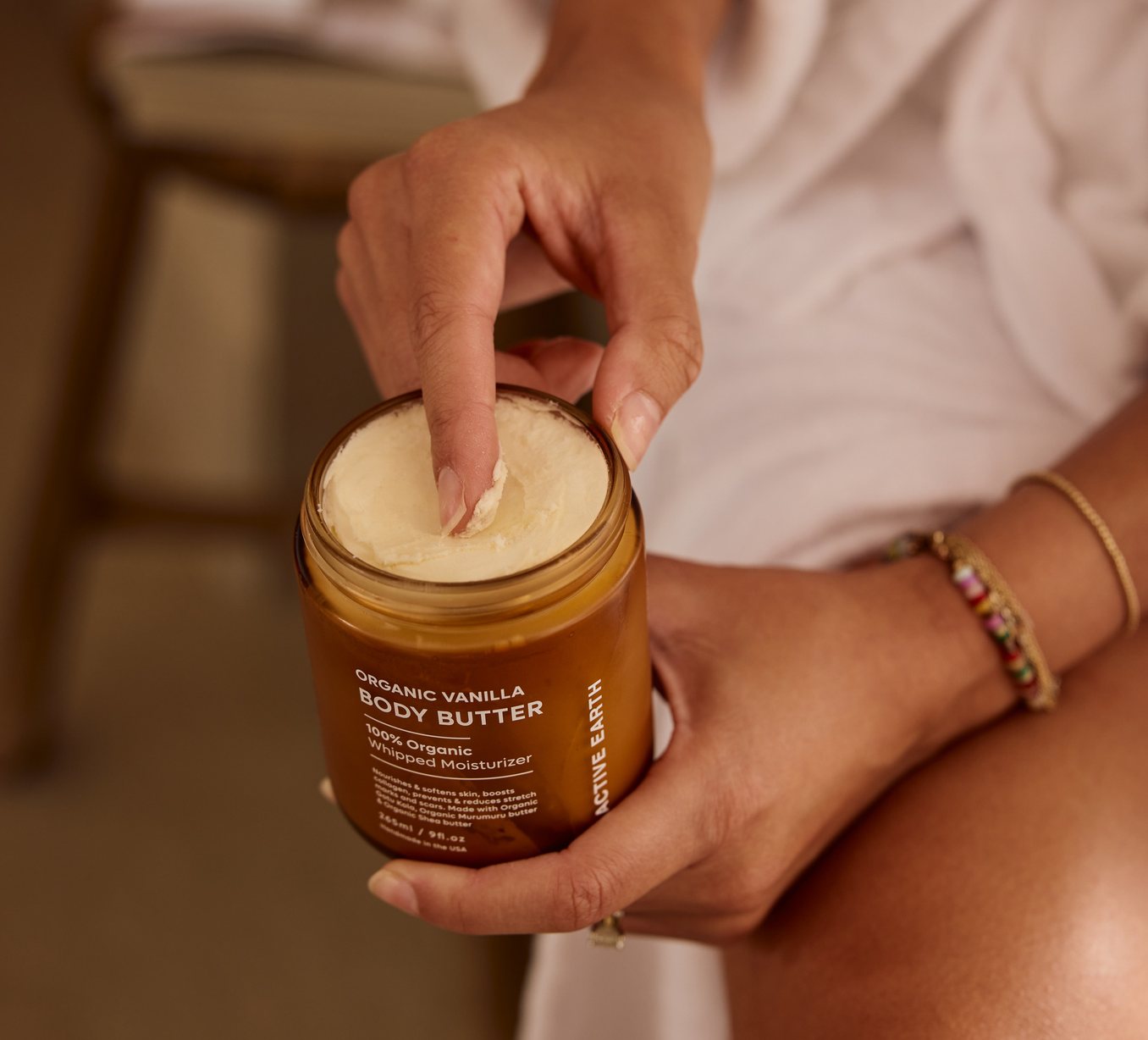 Hand scooping Active Earth Organic Vanilla Body Butter from the jar